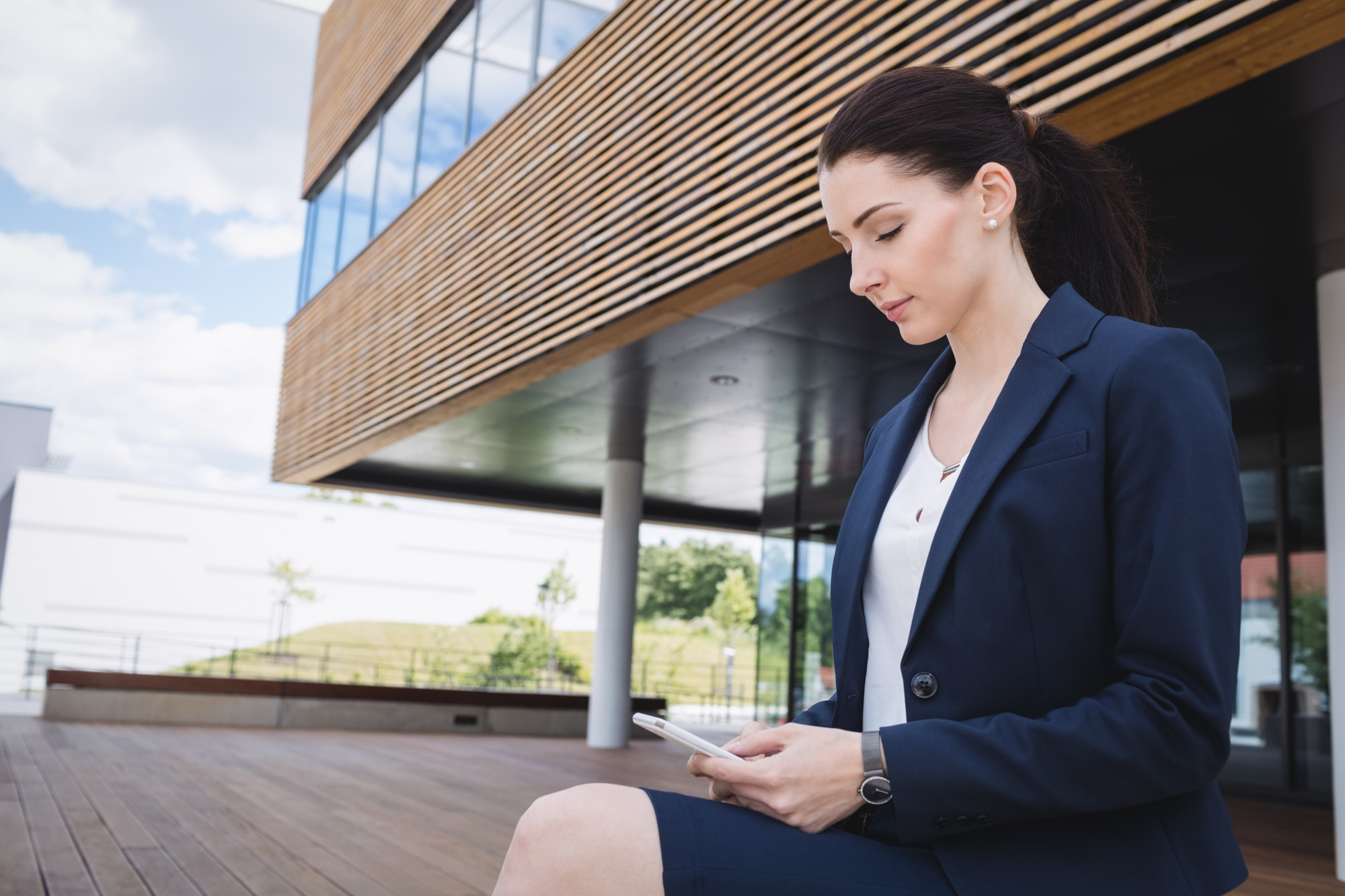 Agente immobilière consultant son smartphone pour un module de formation entre deux rendez-vous