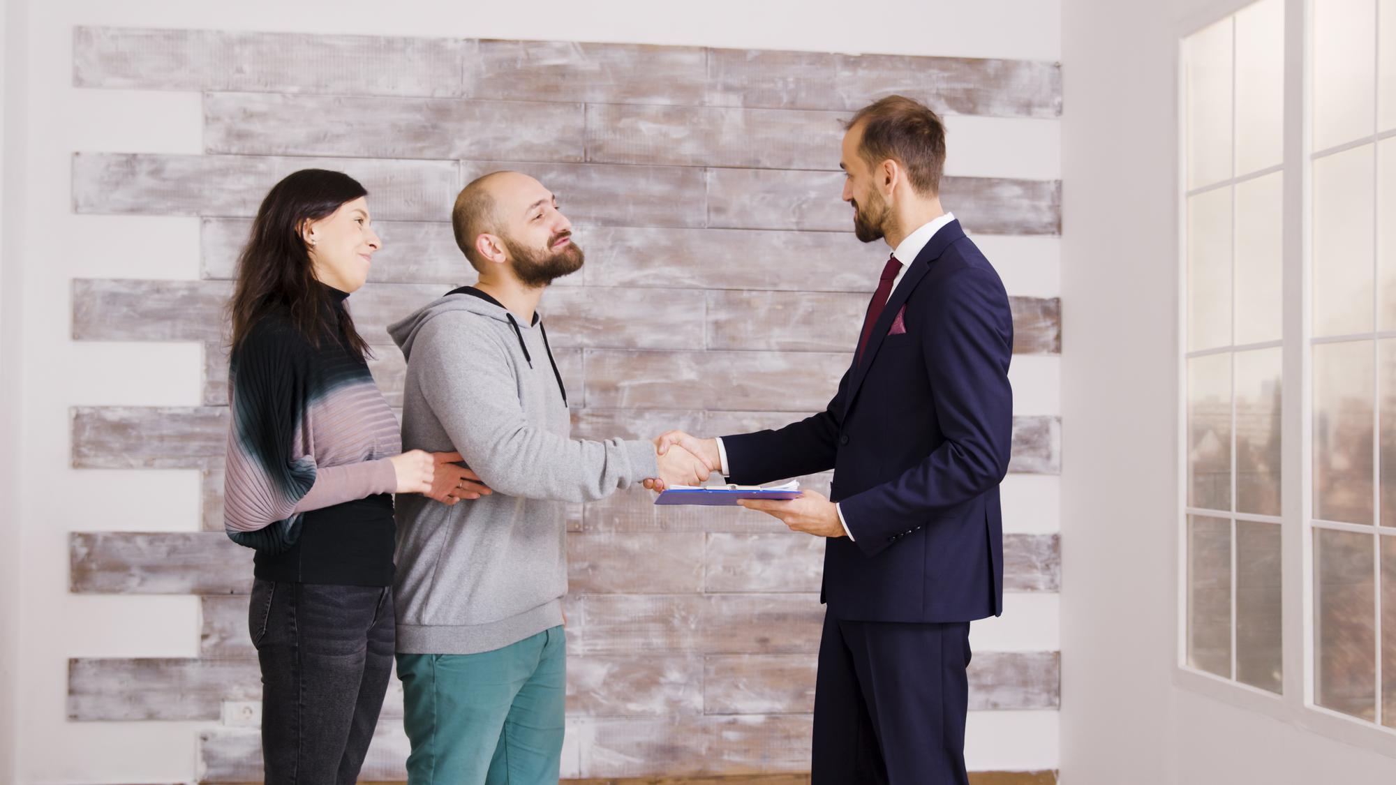 Agent immobilier remettant les clés à un couple après la signature d'un compromis de vente