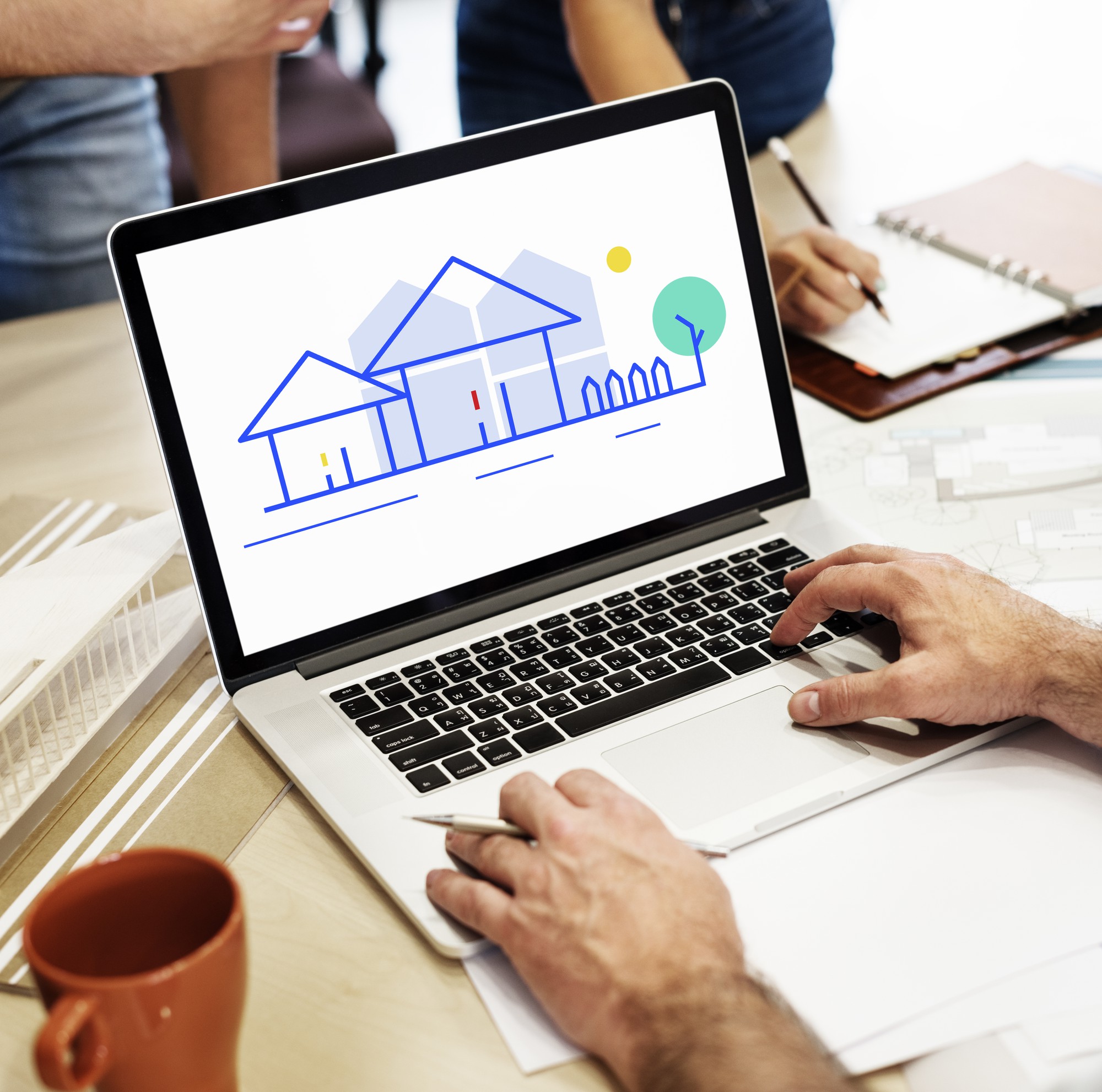 Professionnel travaillant sur un ordinateur portable affichant une illustration immobilière
