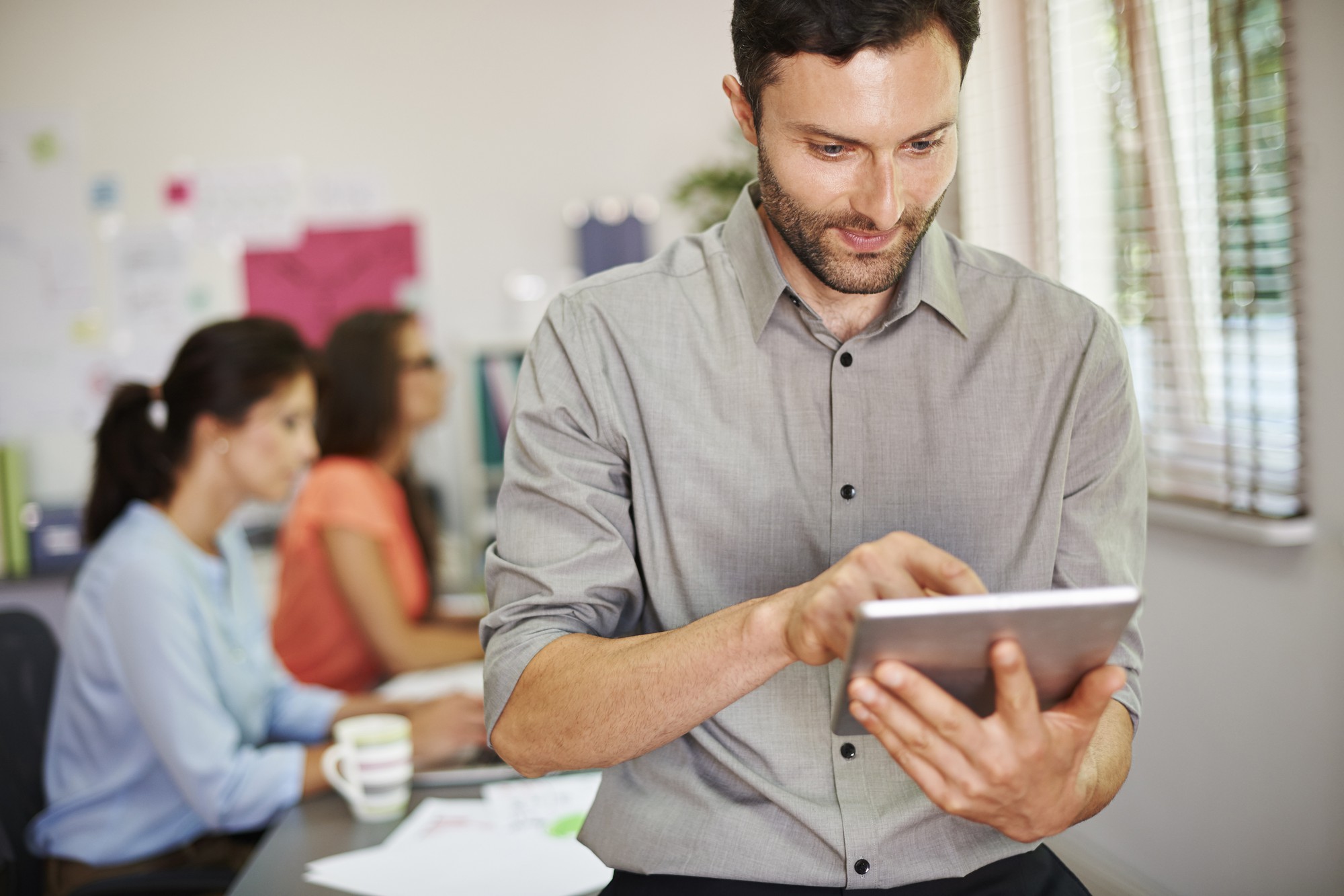 Professionnel consultant une tablette numérique pour suivre une formation en ligne depuis son bureau