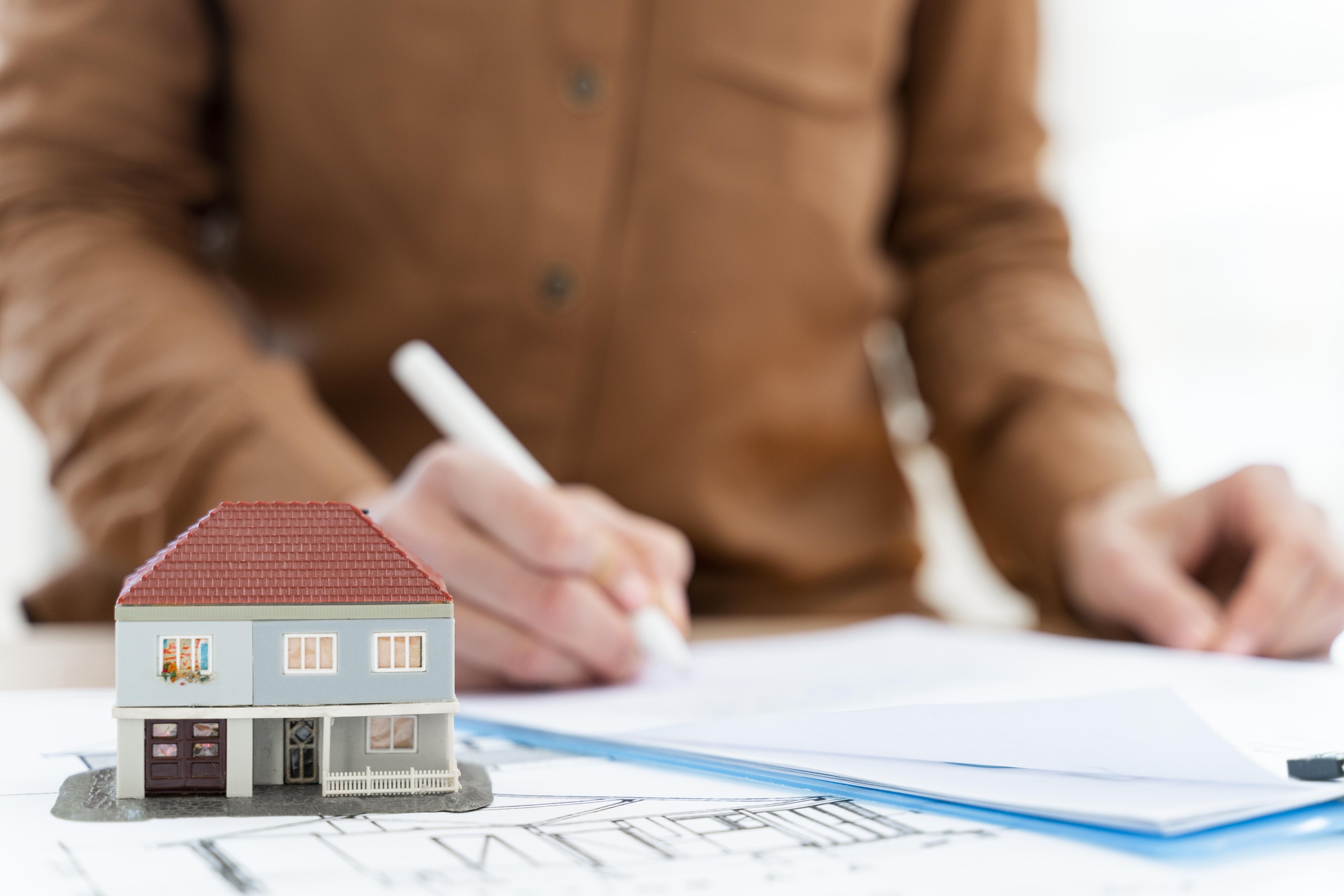 Signature d'un contrat de vente avec maquette de maison